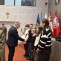 Zdjęcie przedstawia moment składania gratulacji i wręczania nagród uczniom.